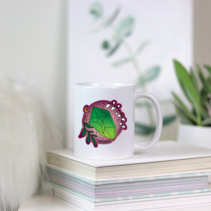 Based in Chicago by queer artist & designer Kayla Pekkala - Tiny Werewolves | May Crystal & Flower Birthstone Mug in | Shop to get your Mug with collections featuring retro-inspired designs infused with social commentary art, highlighting modern social & current events.