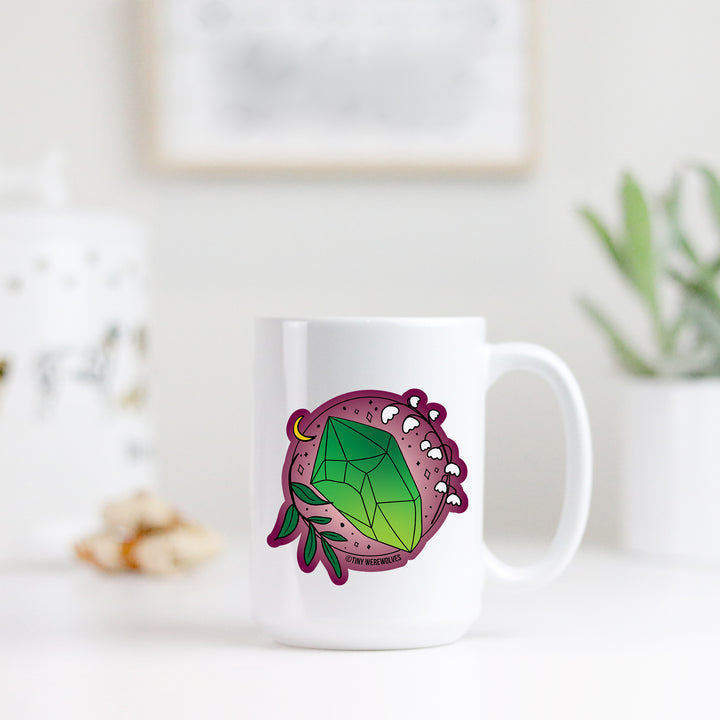 Based in Chicago by queer artist & designer Kayla Pekkala - Tiny Werewolves | May Crystal & Flower Birthstone Mug in | Shop to get your Mug with collections featuring retro-inspired designs infused with social commentary art, highlighting modern social & current events.